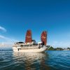 Bai Tu Long Bay Renea Cruise gliding through emerald waters amid majestic islands in a serene and pristine setting