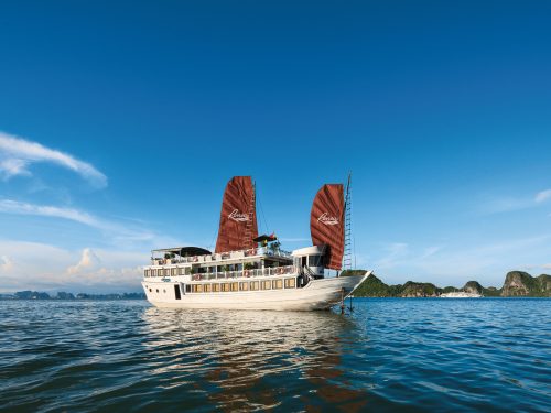 Bai Tu Long Bay Renea Cruise gliding through emerald waters amid majestic islands in a serene and pristine setting