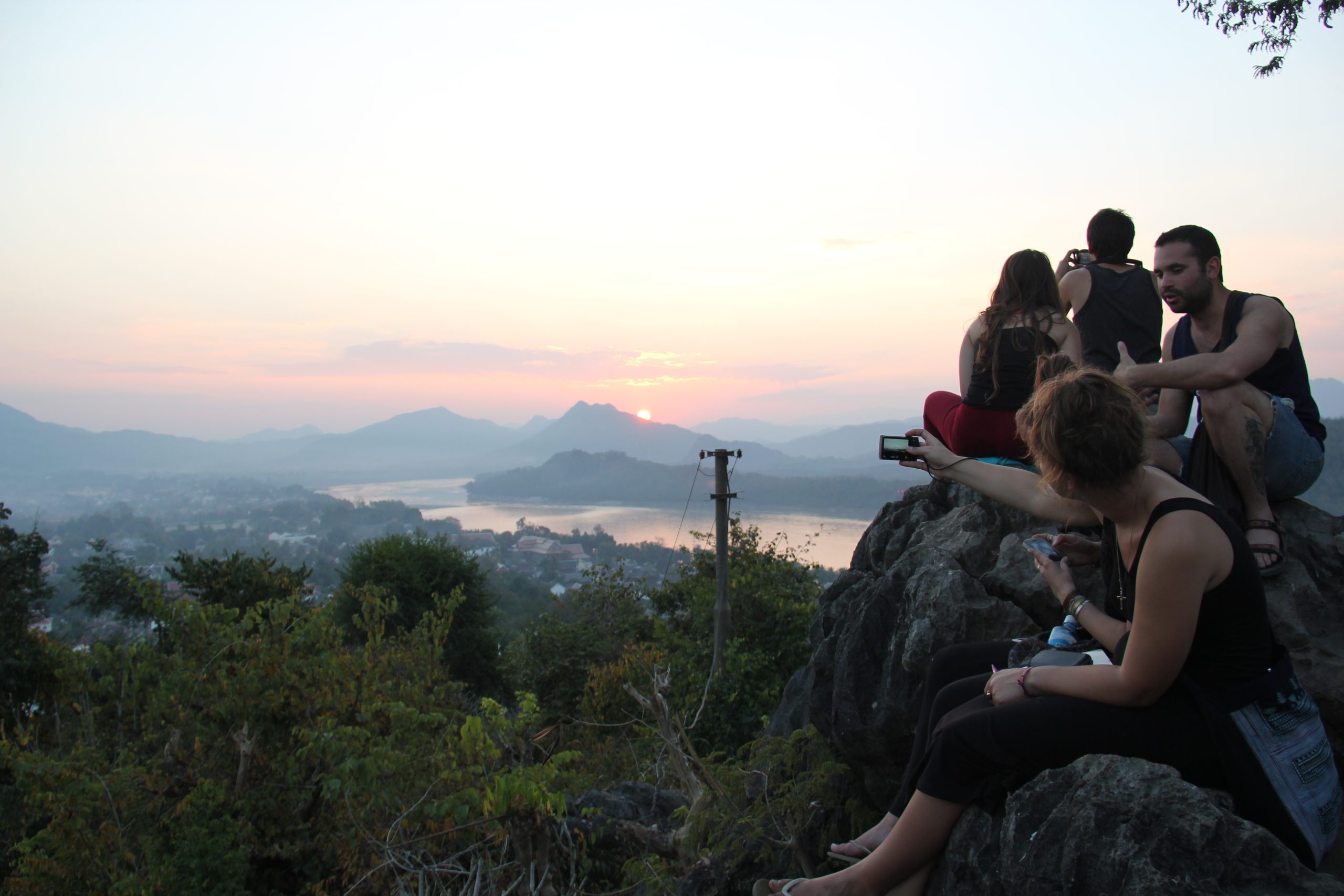 Group of travelers enjoying a 10-Day Laos Adventure, visiting traditional villages, meeting local people, and exploring Laos culture and lifestyle