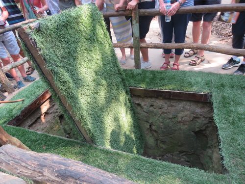 Visitors exploring the Cu Chi Tunnels on a guided day trip from Ho Chi Minh City in southern Vietnam