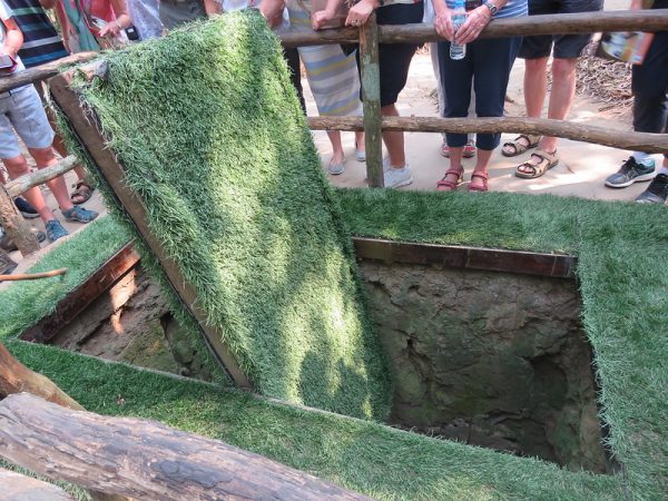 Visitors exploring the Cu Chi Tunnels on a guided day trip from Ho Chi Minh City in southern Vietnam