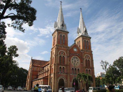 Tourists exploring the Notre Dame Cathedral during a Ho Chi Minh City half day trip