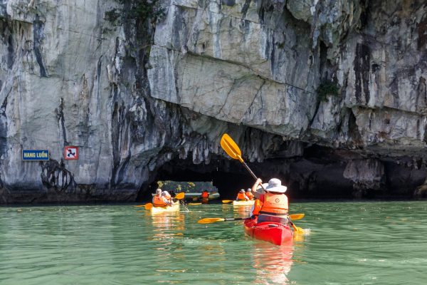 Tourists enjoying Hanoi Halong Bay day trip kayaking at Luon Cave in Ha Long Bay, Vietnam