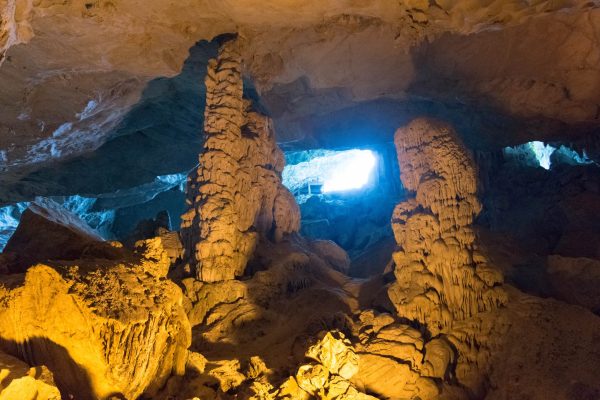 Hanoi Halong Bay day trip cruise ship with tourists exploring Sung Sot Cave and limestone islands in Ha Long Bay