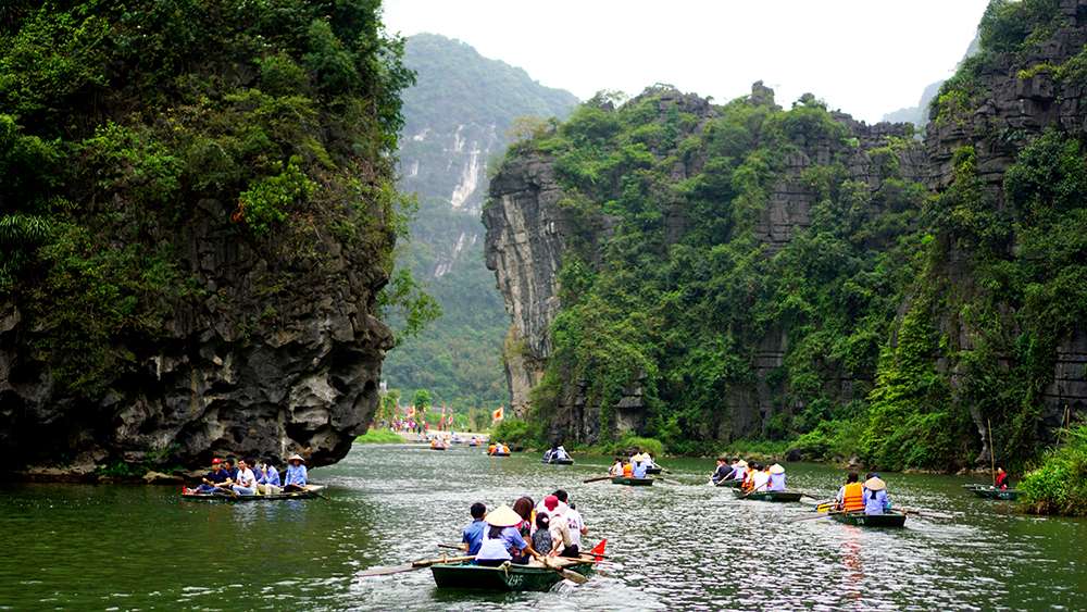 Boating through the scenic limestone valleys of Trang An during a Ninh Binh Day Tour from Hanoi
