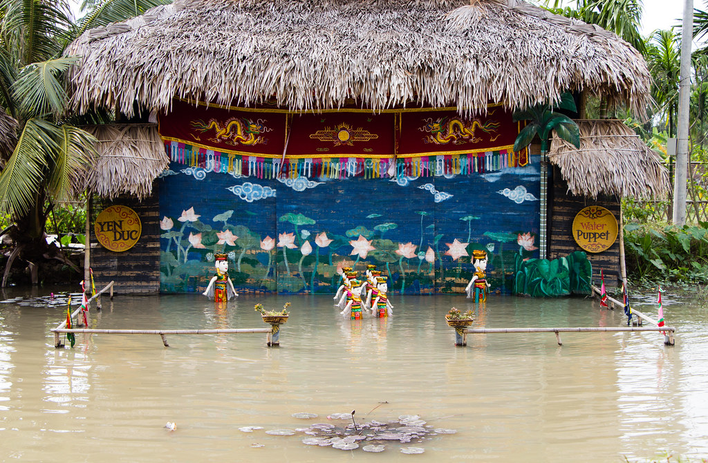 A captivating water puppet show in Yen Duc Village, showcasing traditional Vietnamese culture with puppets performing on water, entertaining an audience of local visitors and tourists