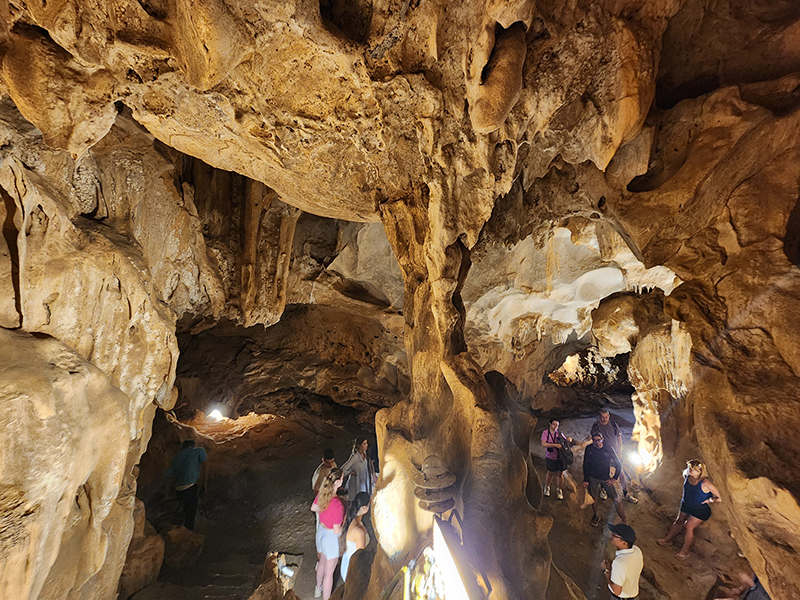 Scenic Thien Canh Son Cave in Bai Tu Long Bay, surrounded by limestone cliffs and tranquil emerald waters