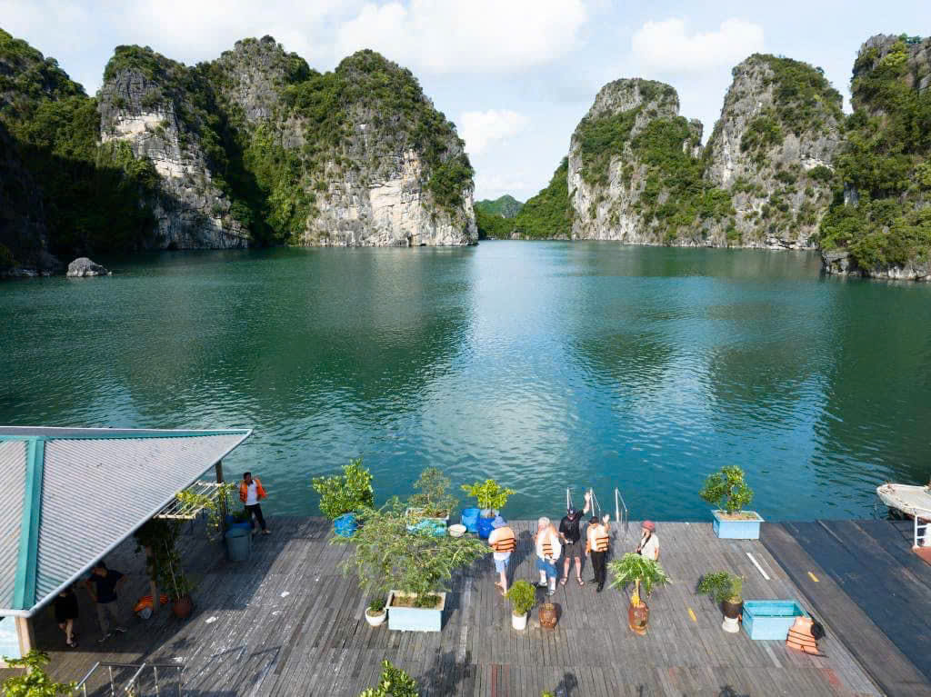 Tourists at Vung Vieng Fishing Village, Bai Tu Long Bay, enjoying the calm water and scenic surroundings