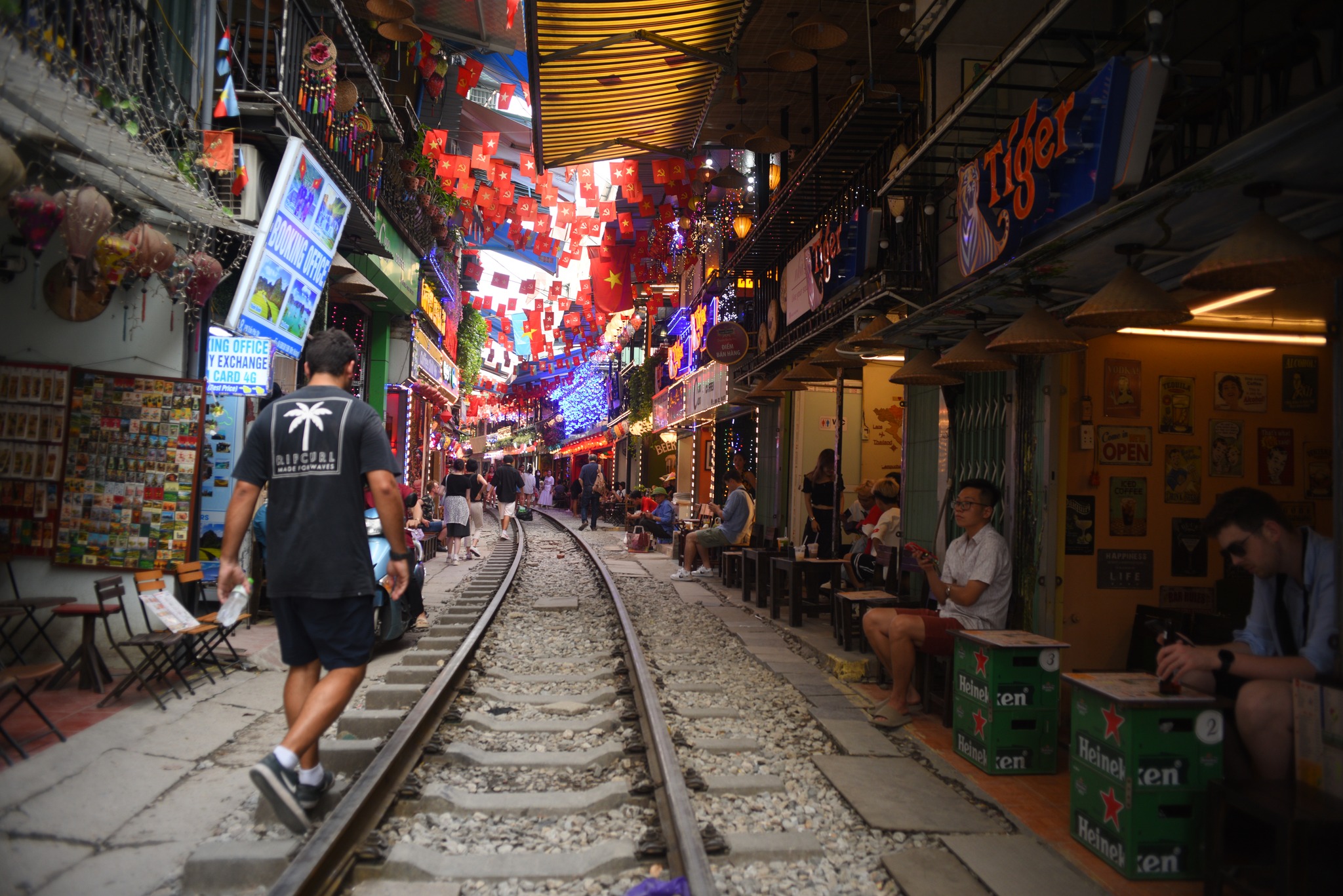 Tourists walking along Hanoi Train Street, a famous railway lane in the heart of Hanoi.