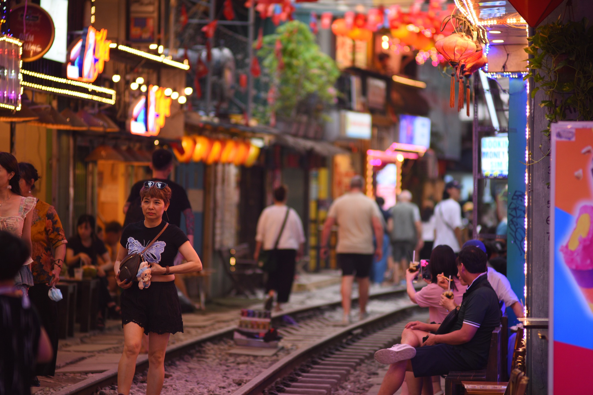 Travelers discovering the unique charm of Hanoi Train Street while walking along the lively railway lane
