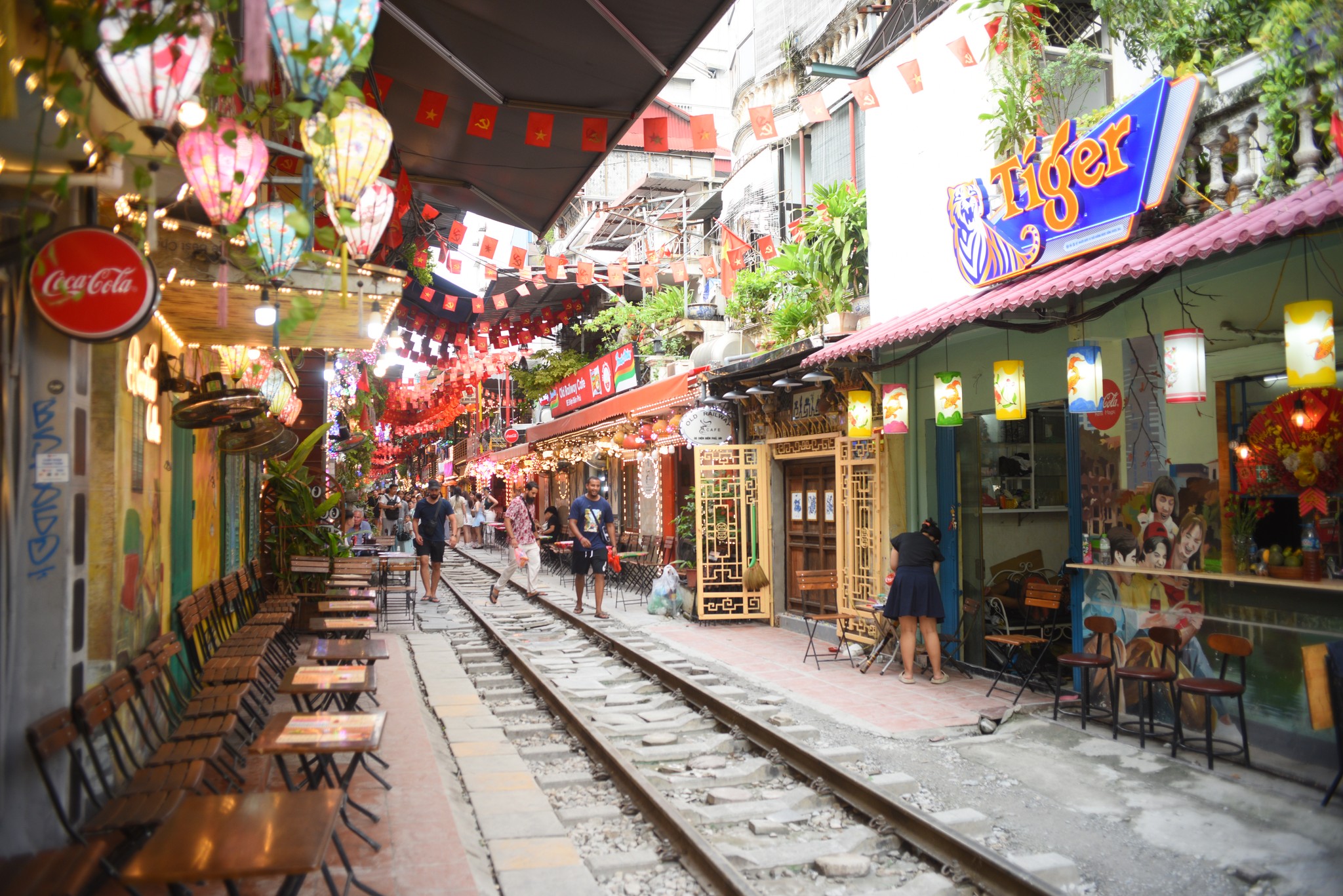Foreign tourists enjoying the unique experience of Hanoi Train Street, a must-visit stop on many Hanoi tours.