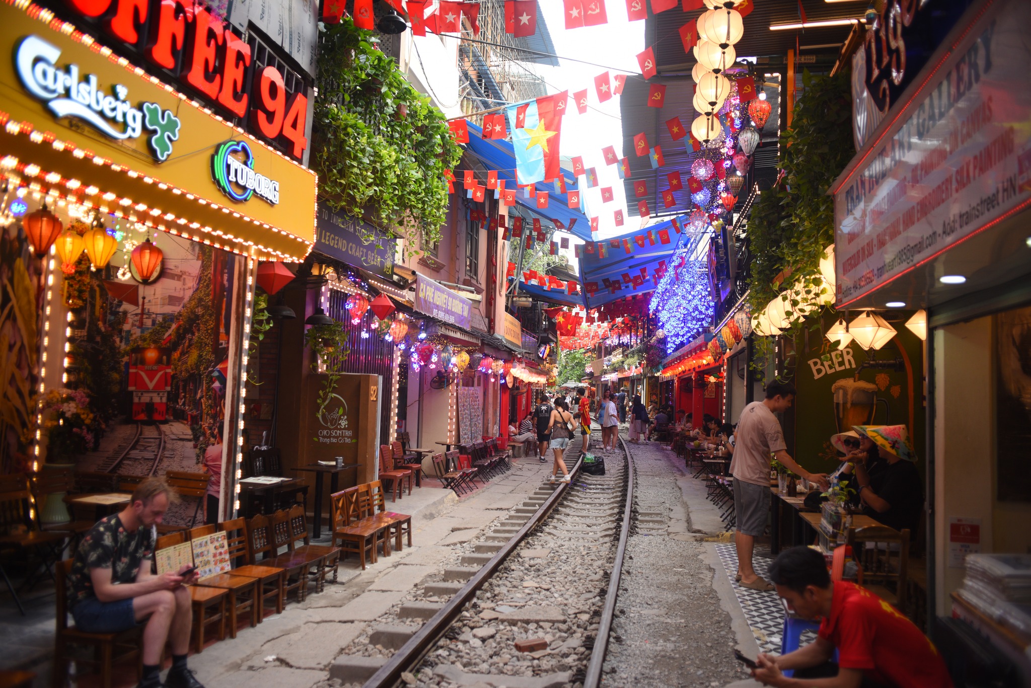 Colorful spots along Hanoi Train Street where visitors enjoy their choice of drinks just inches from the railway